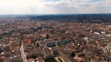 Bordeaux 'un insansız hava aracı panoraması bulutlu gökyüzünün altında yoğun çatı ve şehir planlarını gösteriyor ve şehrin tarihsel mimarisini yakalıyor..