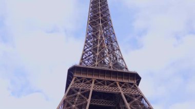 Gündüz Paris 'teki Eyfel Kulesi' nin çarpıcı yükseliş manzarası soluk bulutlu gökyüzüne karşı karmaşık demir yapısını vurguluyor..