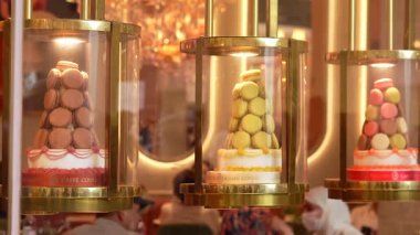 Lüks pastane vitrininde renkli macaron kuleler. Zarif altın çantalar ve Paris 'teki Caffe Konçertosu' ndaki misafirlerin yansımaları. Sadece editörler kullanır. 15 Haziran 2025 'te yakalandı..