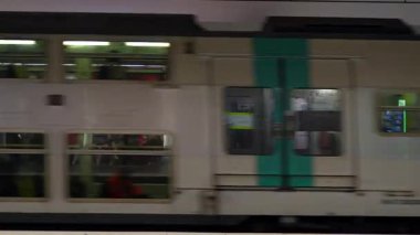 Paris 'teki Charles de Gaulle Etoile istasyonuna ulaşan metro treni, insanlar platformda tabela ve otomatla bekliyorlar. Sadece editörler kullanır. 15 Haziran 2025 'te yakalandı..