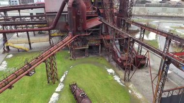 Eski bir sanayi bölgesinde paslı borular ve platformlarla büyük bir patlama fırınının insansız hava aracı çekimi ağır üretim mimarisinin boyutunu ve karmaşıklığını gösteriyor.