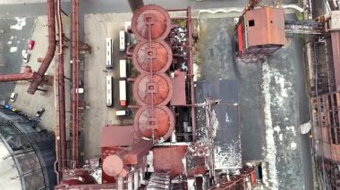 Endüstriyel tankların insansız hava aracı görüntüsü ve kullanımdan kalkmış bir nakliye arabası açık bir alana yerleştirildi. 