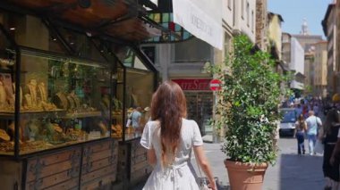 23 Temmuz 2025 'te Ponte Vecchio Florence' da bir kadın dükkan vitrininde geziniyor. 