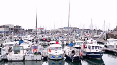 28 Mart 2025 'te Boulogne sur Mer France' ta sakin sulara ve arka plandaki sanayi binalarına demirlemiş sık sıra balıkçı tekneleri ve yatlarla dolu yoğun bir marina manzarası 