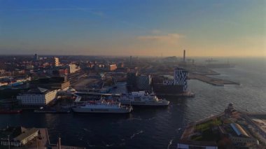 Helsingborg limanının modern mimari ve feribot görüntüsü Oresund Boğazı 'nda 1 Aralık 2024' te güney İsveç 'te günbatımında kaydedildi. 