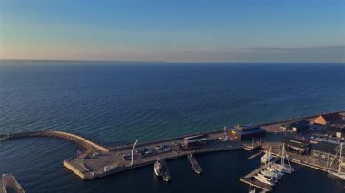 Limandaki liman ve deniz kıyısındaki binaların havadan görünüşü rıhtımdaki tekneleri ve huzurlu bir sahil atmosferini gösteriyor. 