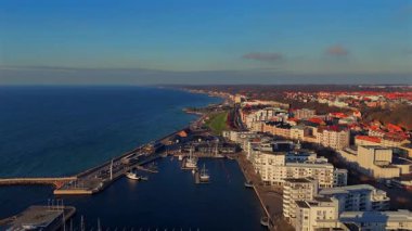İsveç 'in güneyinde güneşli bir günde gezinti marinası ve konut binalarıyla Helsingborg kıyı şeridinin manzaralı manzarası 