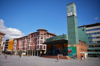 30 Temmuz 2025 'te Barakaldo İspanya' daki modern yeşil saat kulesiyle ana meydanda yürüyen insanlar