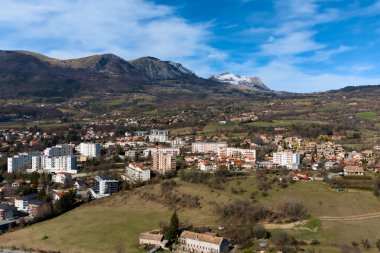 Fransa 'nın güneydoğusundaki Gap banliyö bölgesinin geniş hava manzarası, yerleşim alanları, açık alanlar ve etrafındaki dağlar açık bir yay altında.