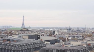 Paris 'in geniş panoramik manzarası Eyfel Kulesi' nin gökyüzü altında tarihi çatıların üzerinde yükselişi 