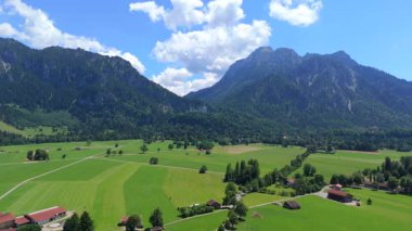 Bavyera 'daki dağlık arazide Lech Nehri' nin aktığı Neuschwanstein Kalesi 'nin havadan görünüşü 