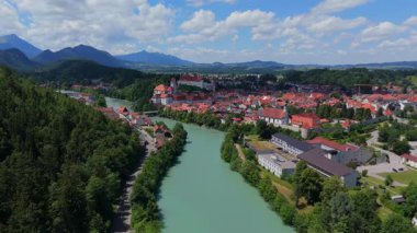 Almanya, Fussen 'in geniş hava görüntüleri, Lech Nehri' ni vurguluyor, tarihi eski kasaba ve gündüz manzaralı dağ manzarası. 