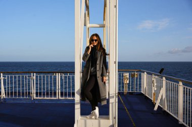 Güvertede okyanus manzaralı genç bir kadın.