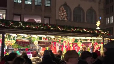 Kalabalık 14 Aralık 2024 'te Münih' teki Noel pazarının keyfini çıkarıyor. Işık çelenkleri ve bayram hediyeleriyle süslenmiş bayram tezgahlarına göz atıyorlar. 