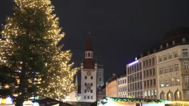 Münih Münih 'teki Marienplatz' da aydınlatılmış Noel ağacı ve şenlikli pazar tezgahları. 
