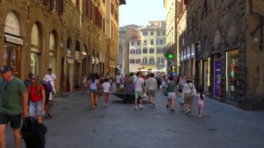 İnsanlar 4 Temmuz 2025 'te Floransa' da güneşli bir yaz gününde taş binalar ve mağazalarla tarihi alışveriş caddelerinde yürüyorlar. Sadece editör kullanımı