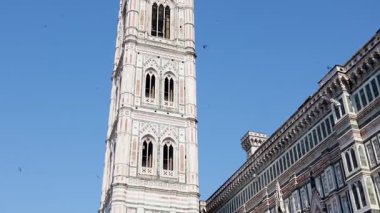Giotto Campanile ve Floransa 'daki katedralin süslü mermer cephesi mavi gökyüzünün altında.