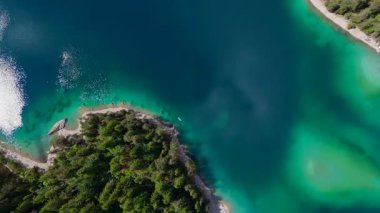 Turkuaz Gölü kıyısında, kumlu hava ormanları kıyısı.