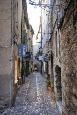 Fransa 'nın tarihi Saint Paul de Vence köyünde tarihi taş evleri ve tabelaları olan dar kaldırım taşı caddesi, 5 Temmuz 2025. Sadece editör kullanımı. 