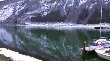 Kış fiyort sahnesi karlı kayalık kıyı ve dağ yansımaları