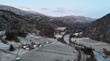 Gaupne Norveç 'in havadan görünüşü. Kırmızı evler, buzlu tarlalar, kıvrımlı nehirler ve karlı dağlar.