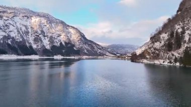 Sakin fiyort berrak mavi suyla karlı dağlar ve parlak kış gökyüzü