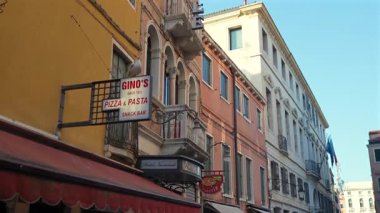 Turistler Ginos Pizza Restoranı 'nın önünden geçiyorlar. Venice 29 Haziran 2025 editoryal.