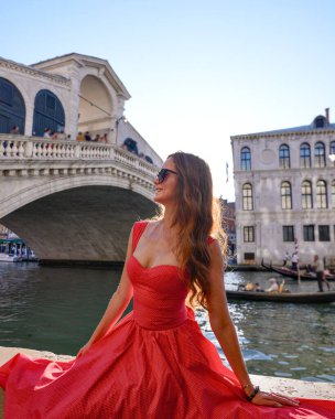 Rialto Köprüsü yakınlarında poz veren kırmızı elbiseli manken.