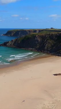 Kuzey İspanya 'da altın kum kayalıkları ve okyanus dalgaları olan sahil 