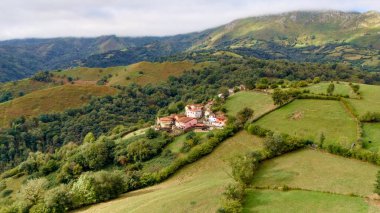Kır manzaralı evler, tarım arazileri ve yuvarlanan tepeler