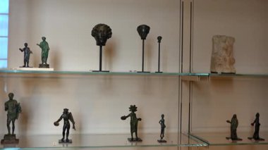 Antik bronz heykelcikler ve küçük heykeller 1 Haziran 2025 'te Paris müzesinde sergilenen ve tarihi sanat ve zanaatkarlığın sergilendiği cam bir kutuda sergilenmektedir. Sadece editör kullanımı.