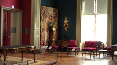 Bir Paris müzesinde 1 Haziran 2025 'te çekilen antika mobilyaları, kırmızı kadife sandalyeler, süslü masa ve dekoratif duvar halılarıyla sergi salonu. Sadece editör kullanımı.