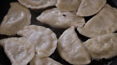 Tavada yağda kızaran Rus pierogi buharı havaya yükseliyor.. 