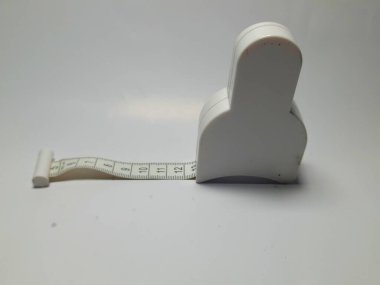 Beyaz arka planda izole edilmiş siyah ve beyaz bir mezura.