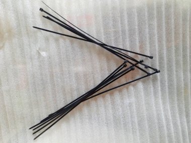 Beyaz arka planda siyah beyaz bir iğnenin yakın plan fotoğrafı.