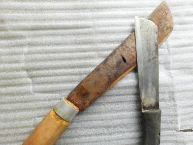 Beyaz bir yüzeyde paslı metal bir çekicin yakın çekimi.