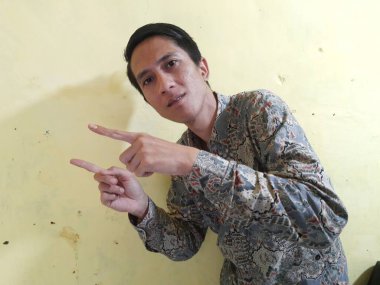 Siyah gömlekli ve siyah eşarplı Asyalı bir adamın portresi.