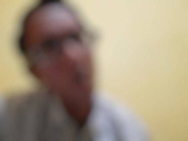 Masada oturan bir adamın bulanık görüntüsü..