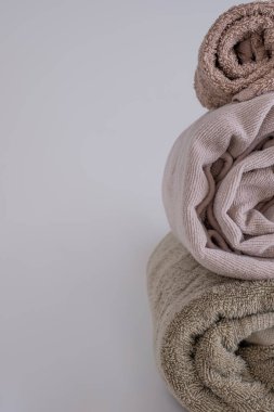 Tarafsız tonlarda sarılmış havlular dikey olarak dizilmiş, dokuları ve yumuşaklıkları vurgulanıyor. Temiz kompozisyon konfor ve organizasyonu vurguluyor