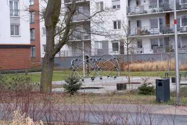 A vibrant playground located in an urban residential area. The photograph captures the contemporary housing architecture surrounding the playground, featuring modern design elements. The playground clipart