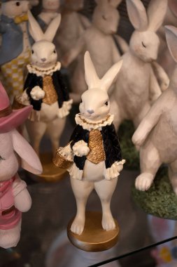 A ceramic rabbit figurine dressed in an elegant black and gold outfit, holding a small basket. The figurine is part of an Easter-themed collection displayed in a store. A great image for Easter clipart