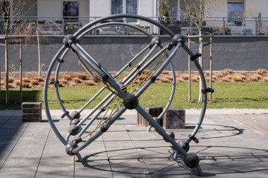 Yuvarlak metal halkalar ve sarı iplerin yer aldığı çağdaş tırmanma alanının geniş görüşü. Çocuk etkinliği, kentsel tasarım, güvenlik standartları ve eğitim alanlarıyla ilgili konular için ideal. 