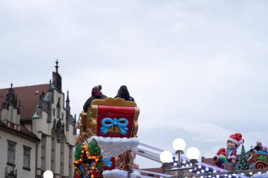 Polonya 'nın Wroclaw kentindeki tarihi binaların arka planında insanların Noel kızağı gezintisinin tadını çıkardıkları bir manzara. Tatil dekoru ve mimari çekiciliğin birleşimi,
