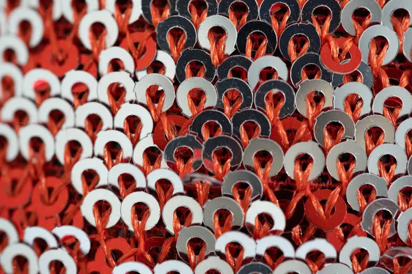 Parlak kırmızı ve gümüş pulların yakın plan görüntüsü. Parlak, karmaşık bir desen şeklinde örülmüş. Fotoğrafta kumaşın canlı dokusu ve ışıltılı ayrıntıları sergileniyor ve moda başyazıları, tekstil tasarımları ve kutlama temalarında kullanılmak için ideal hale getiriliyor.
