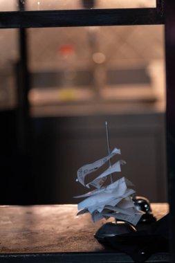 Mutfak arka planı bulanık bir şekilde tezgahın üzerinde buruşmuş sipariş kağıtlarıyla dolu metal bir makbuz tutacağının yakın çekimi. Görüntü, kafelerin, restoranların ve küçük işletmelerin yoğun ritmini yansıtıyor. Konukseverlik ve hizmet sektörüne uygundur., 