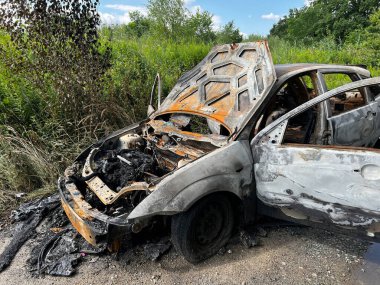 Kaputu açık, kömürleşmiş ve paslanmış bir motoru ortaya çıkaran ağır yanmış bir araba yoğun yeşil bitki örtüsünün yanındaki kırsal bir yol kenarında terk edilmiş. Olaydan sonra meydana gelen kazaları, araç yangınlarını veya