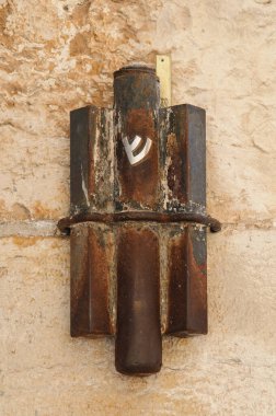 İsrail 'in Kudüs kentindeki Jaffa Kapısı' nın girişindeki taş bir duvara yapıştırılmış büyük, paslı, metal mezuzah çanta.. 