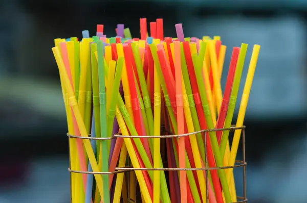 Çok renkli, plastik, tek kullanımlık pipetler ve kabın içinde duran körükler.. 
