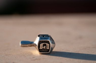 A small silver cast dreidel top used during a game played on Hanukkah, the Jewish festival of lights.  clipart