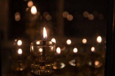 İsrail 'deki Işık Festivali' nin kutlaması sırasında küçük şişelerde balmumu yakmak yerine geleneksel olarak yağın yakıldığı Kudüs 'teki bir evin dışında yanan Hanuka mumlarının alevleri.. 